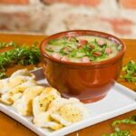 Caldo verde num pote de barro com torradas ao lado