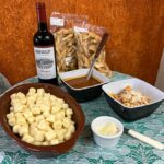 nhoque de batat com um pote de molho ao sugo e queijo parmesão ralado